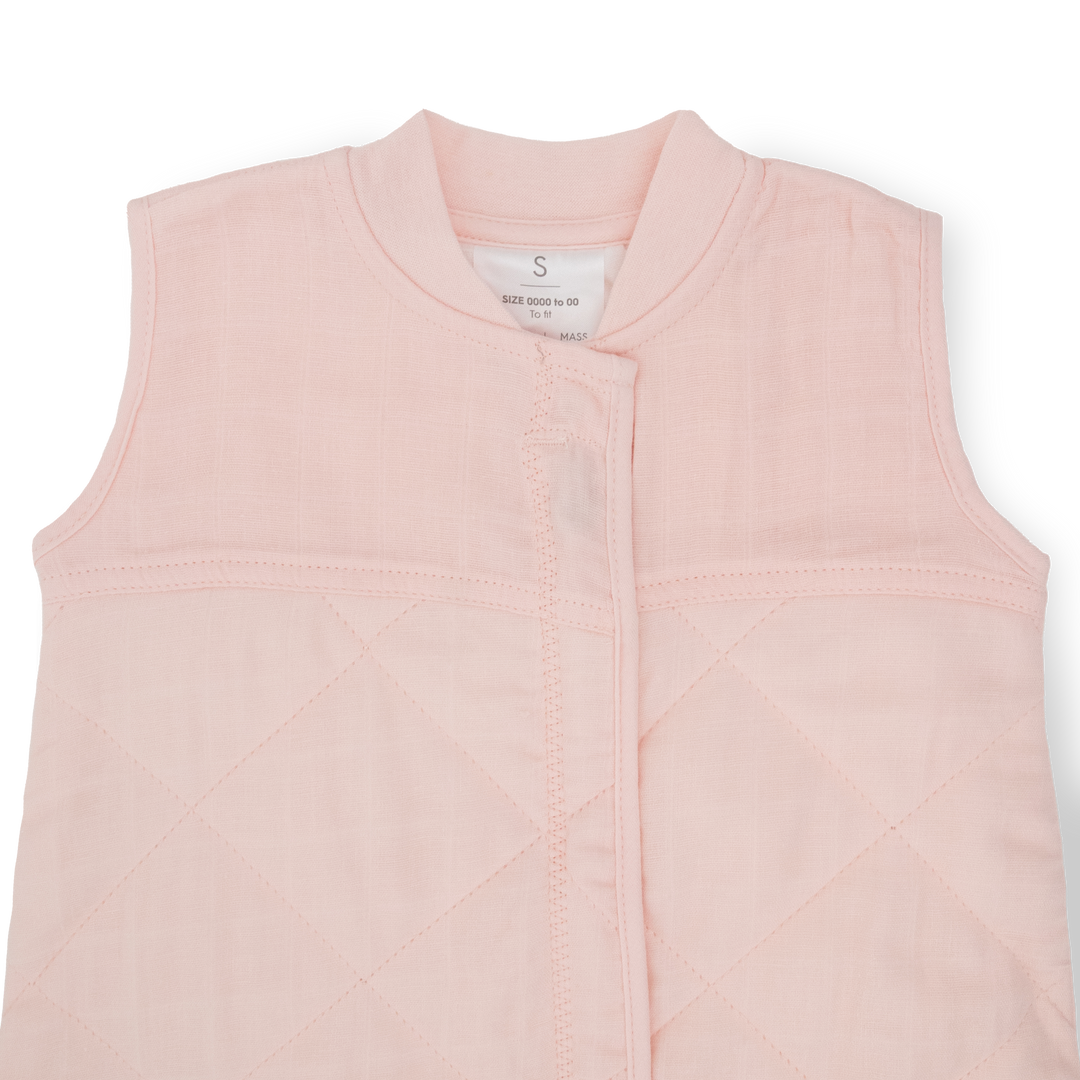 Flat lay of Little Unicorn Cotton Muslin Quilted Sleep Bag - Light Pink, infant sleeping bag for nursery comfort.
