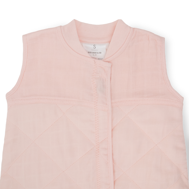 Flat lay of Little Unicorn Cotton Muslin Quilted Sleep Bag - Light Pink, infant sleeping bag for nursery comfort.