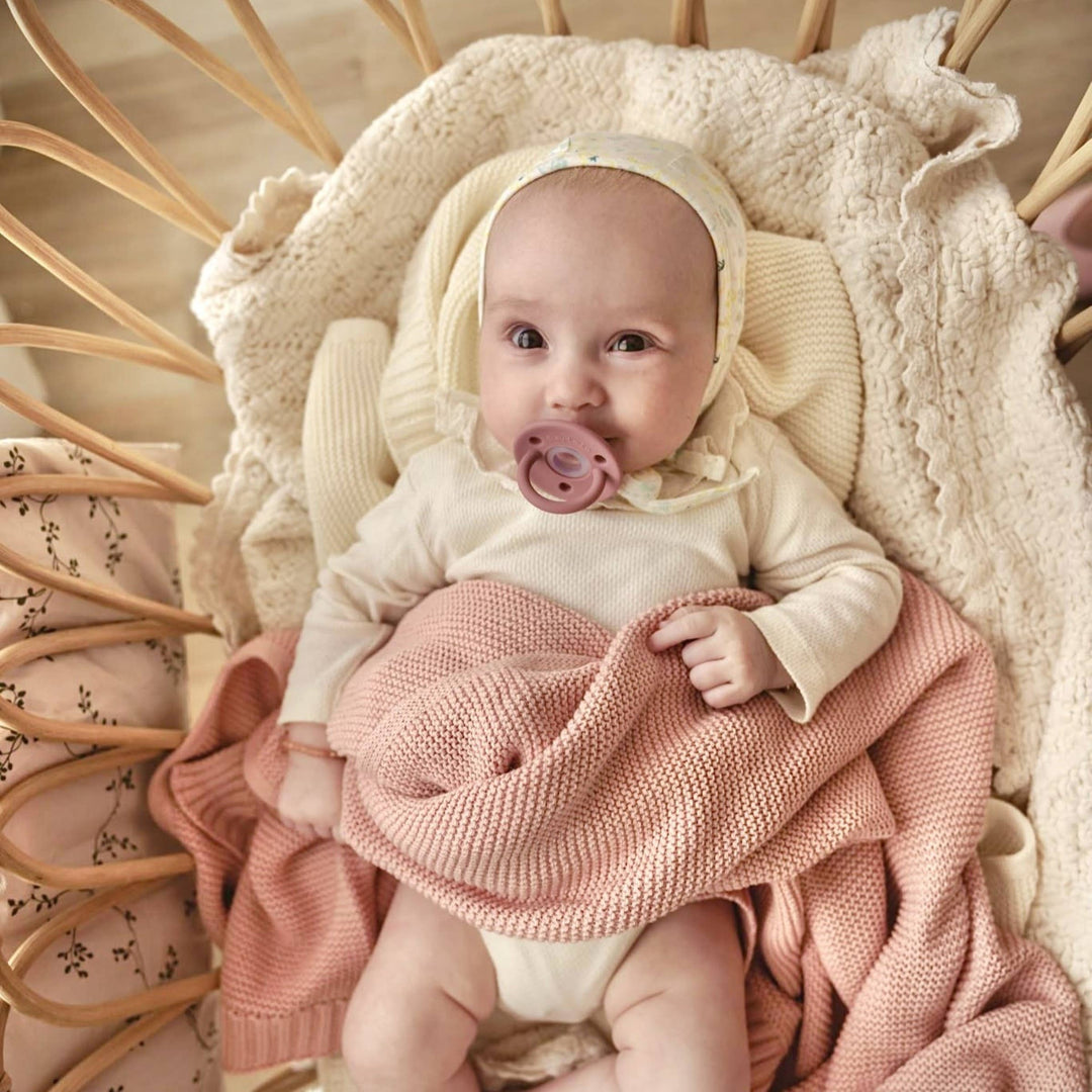 Baby in Crib using the Bleu La La Heritage 100% Organic Cotton Knitted Swaddle in Blush Pink