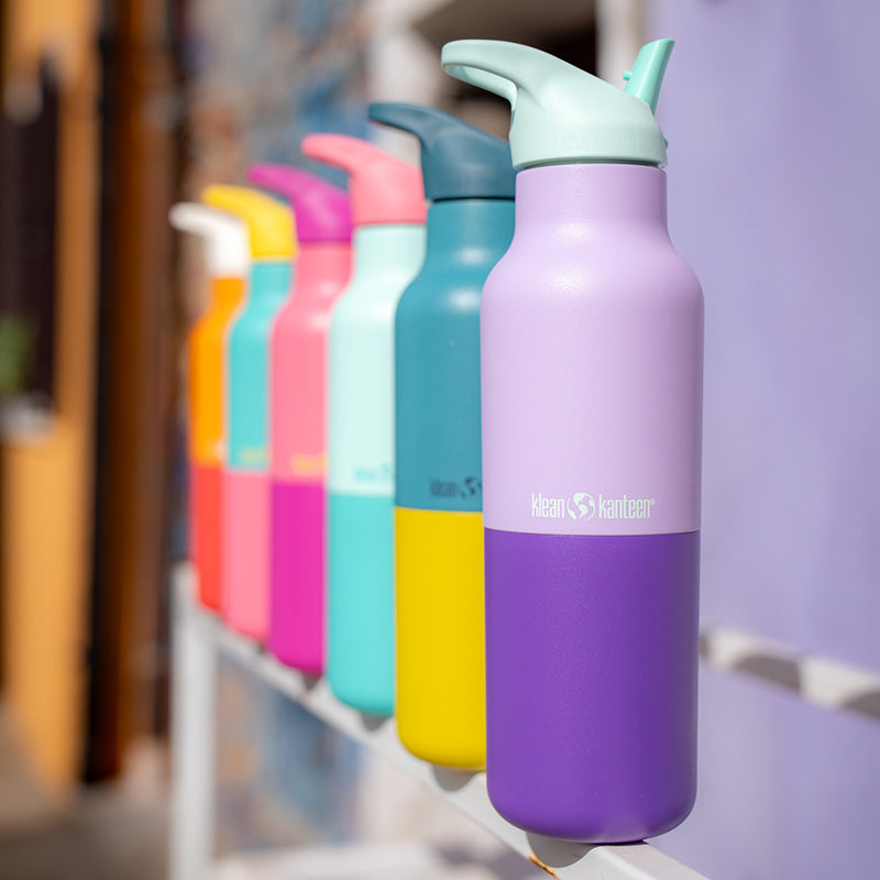Lineup of Klean Kanteen Rise Classic Bottles in Kaleidoscope colors, highlighting natural materials and sleek design.