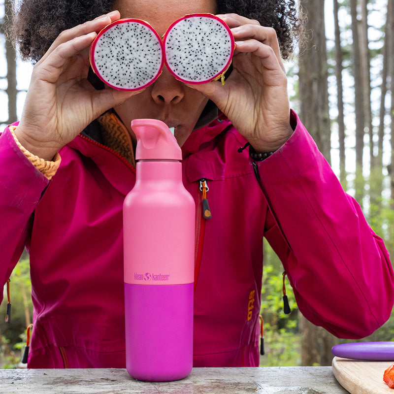 Smiling woman with Klean Kanteen 16oz Rise Classic Water Bottle in Turquoise Kaleidoscope, ideal for cold drinks and everyday hydration.