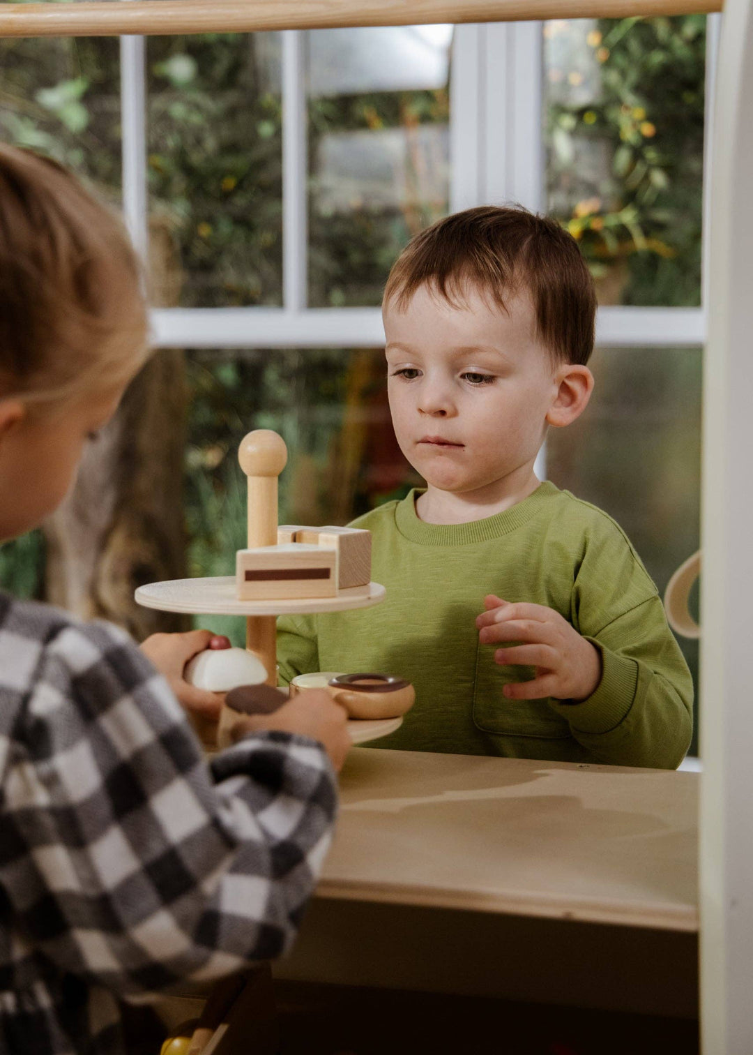 The Coco Village Wooden Desserts Tower encourages fine motor skills and imaginative play through stacking, sorting, and serving.