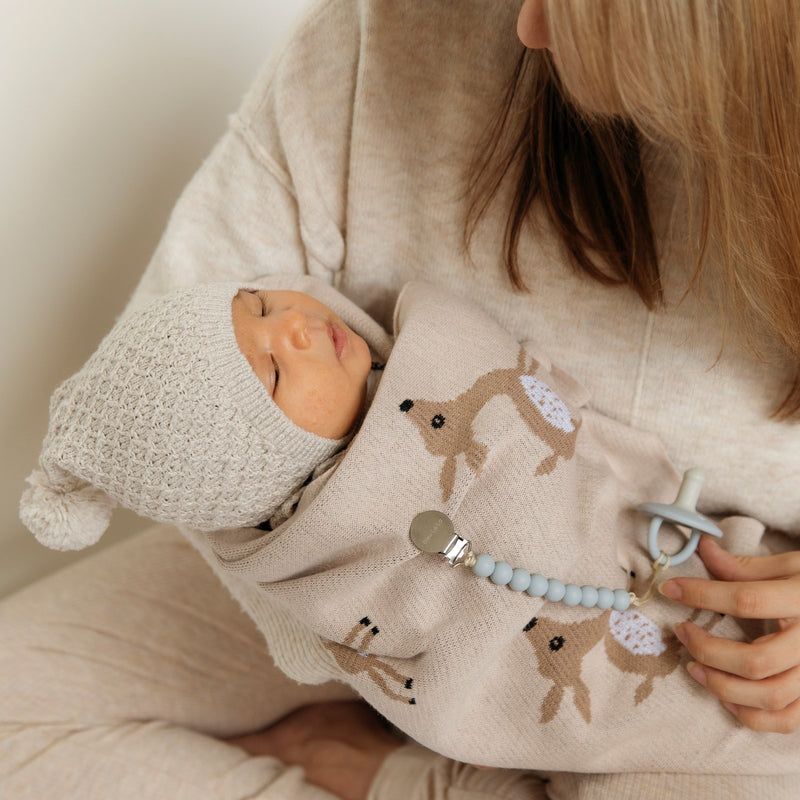 Baby bundled in a Bleu La La deer knit blanket, ideal as a newborn swaddle or lightweight stroller blanket