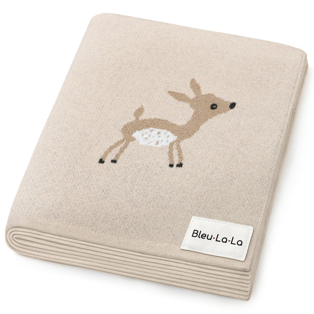 Flat lay of Bleu La La knit swaddle blanket with deer motif, gender neutral baby blanket for nursery styling