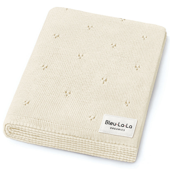 Bleu La La Organic Pointelle Luxury Knit Swaddle Blanket in butter cream, neatly folded to highlight organic cotton softness.