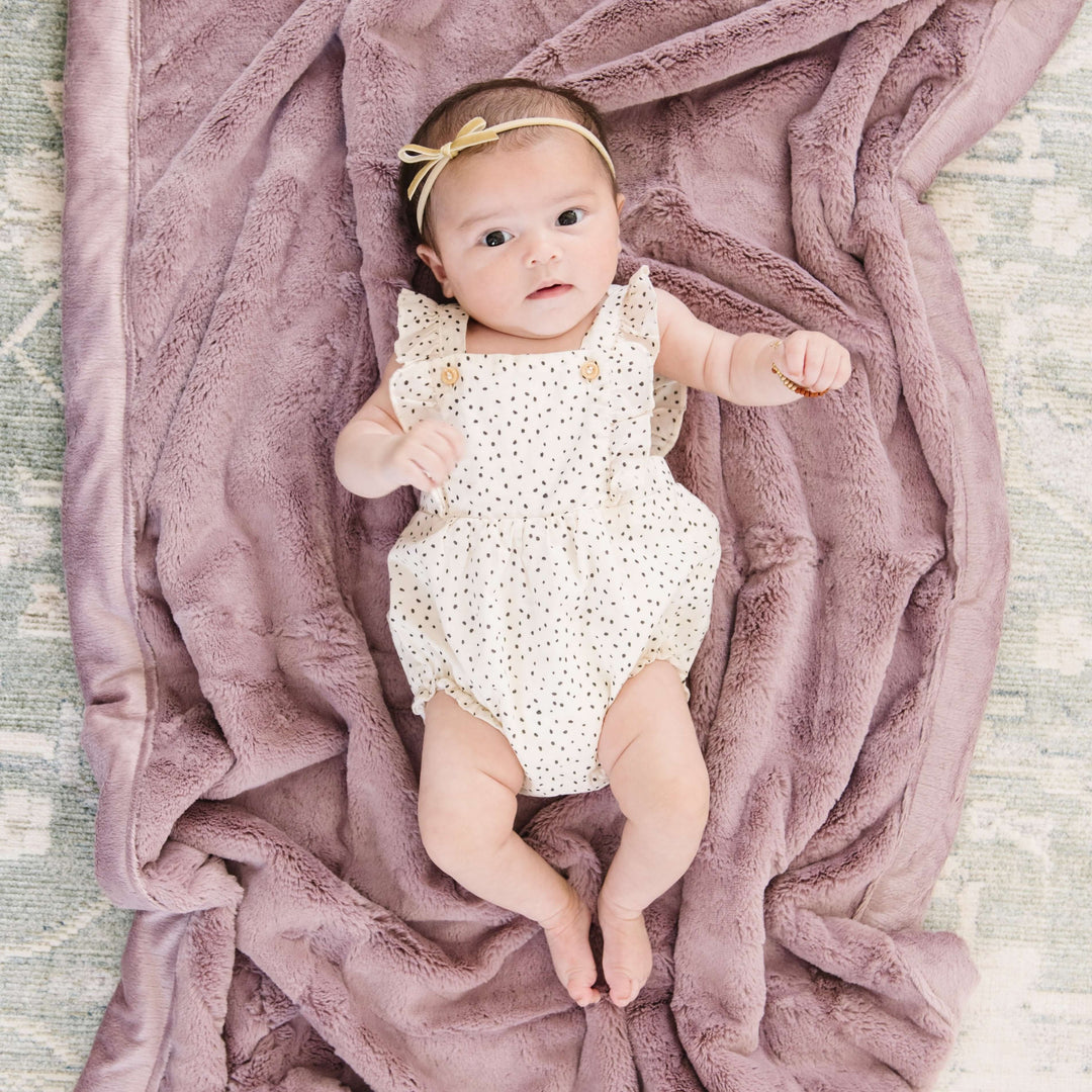 Snuggle your newborn in the Bloom Saranoni Lush Receiving Blanket, a soft receiving blanket for gentle cuddles.