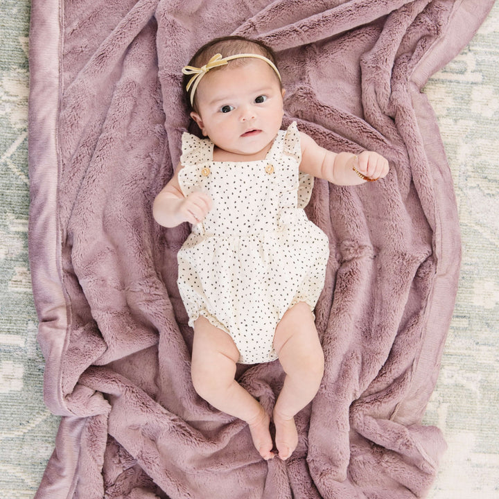 Snuggle your newborn in the Bloom Saranoni Lush Receiving Blanket, a soft receiving blanket for gentle cuddles.
