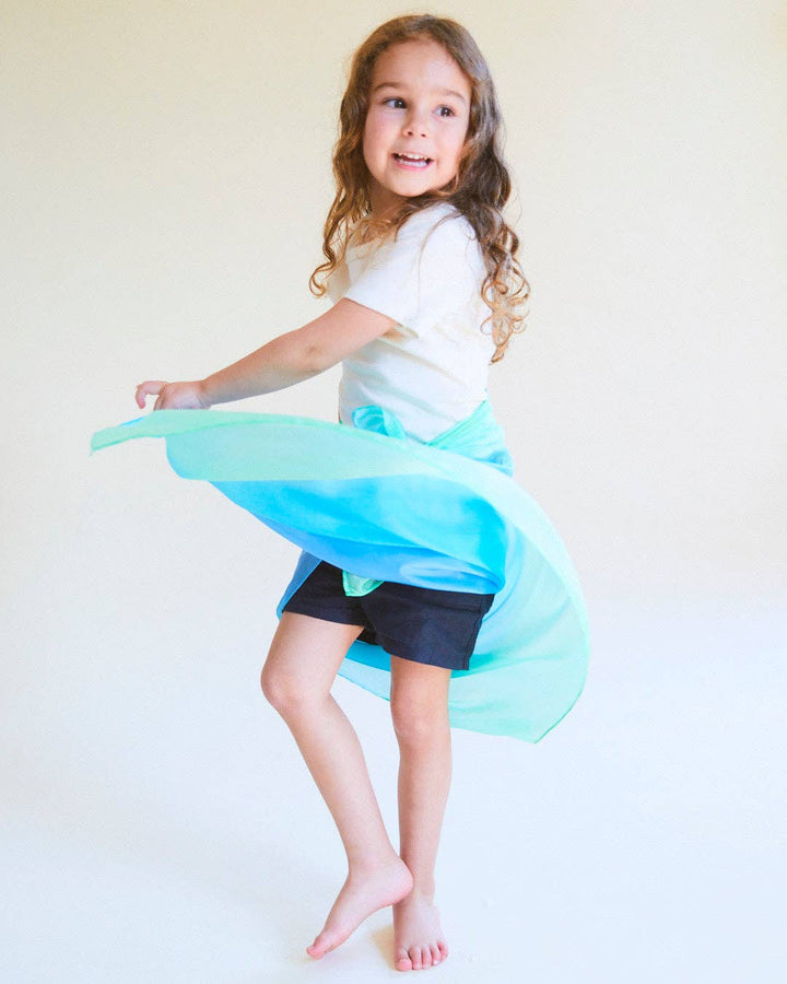 Child twirling with sea silk playsilk