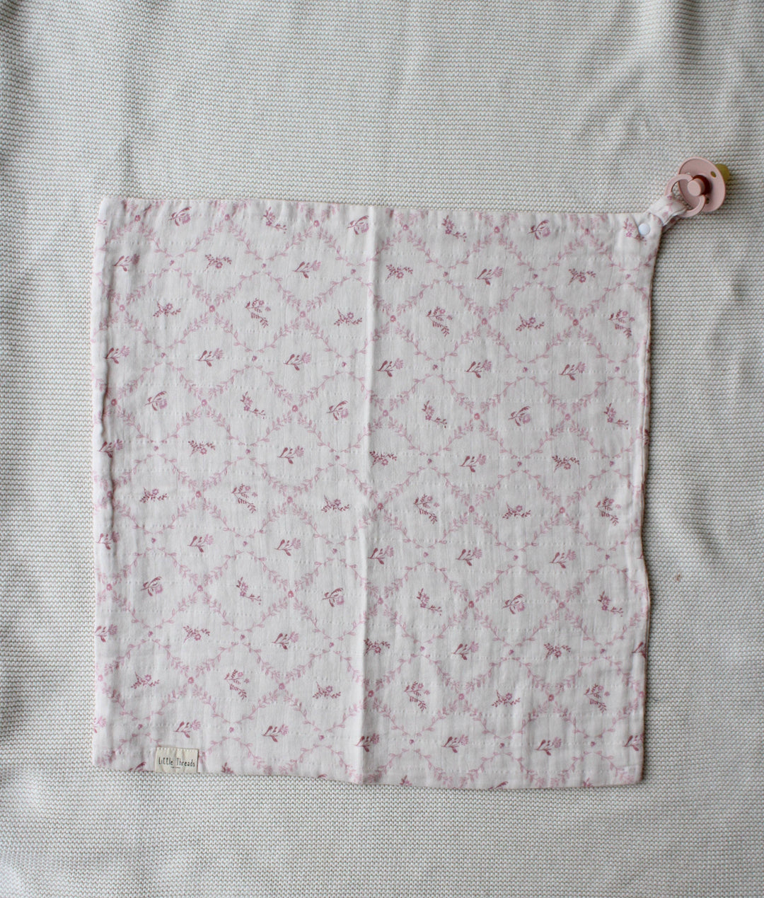 Soft mauve lattice security blanket from Little Threads unfolded to display quilted texture