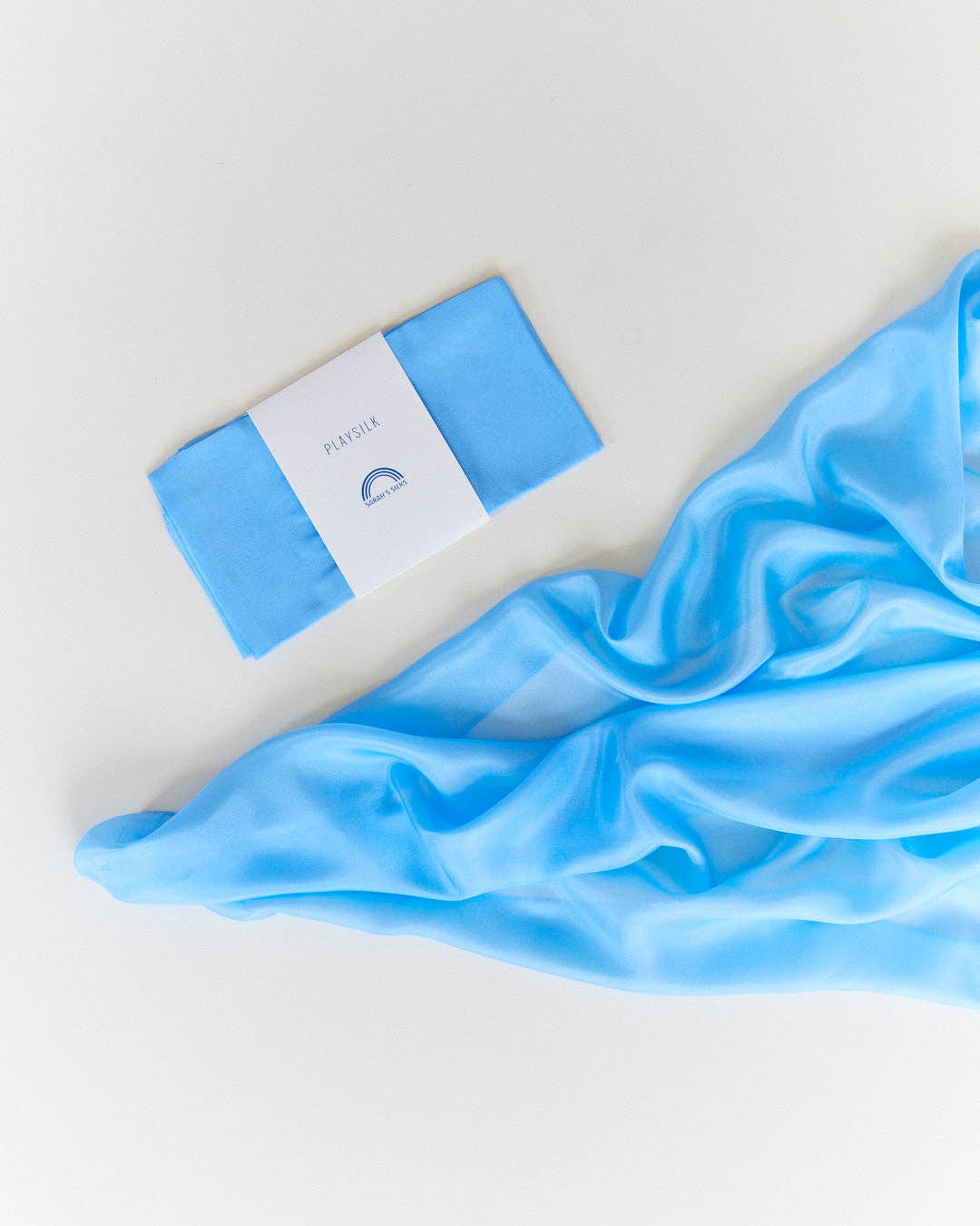 Flat lay of a sky blue Sarah's Silks Solid Color Playsilk, adored by kids everywhere