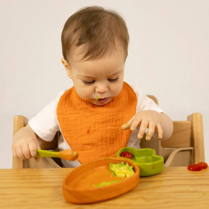 toddler eating avocado from illi and carol cathy carrot wooden plate for baby 