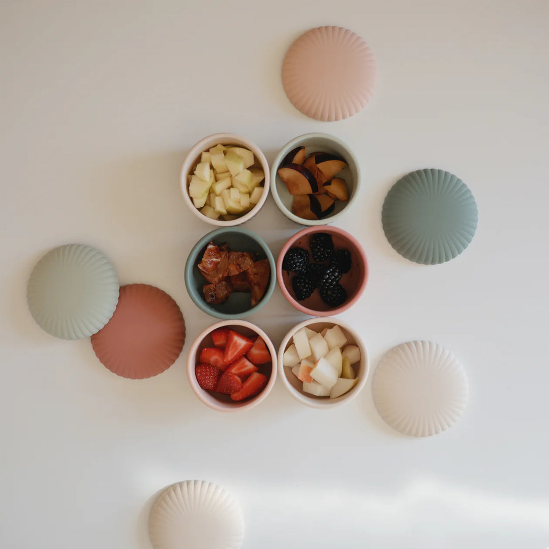 Mushie silicone food containers in use - baby food storage containers filled with colorful healthy snacks