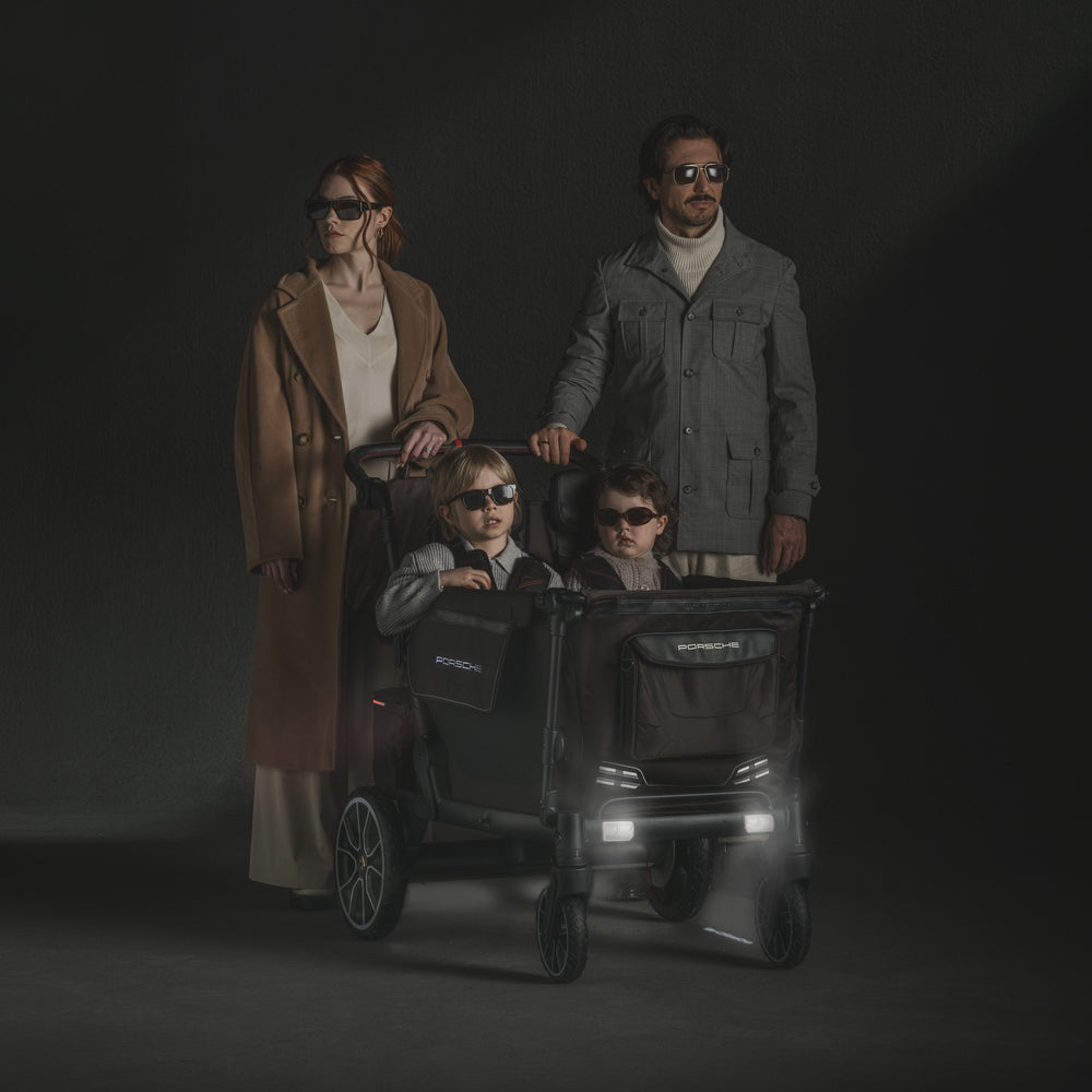 Porsche L4 Quad Stroller Wagon by Wonderfold with headlights on, a luxury wagon stroller for night walks