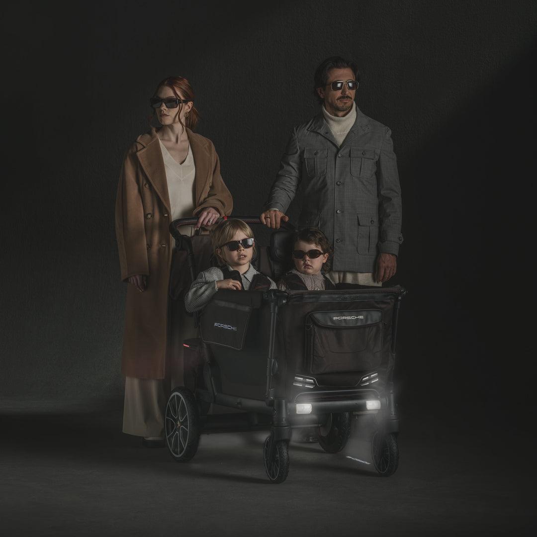 Porsche L4 Quad Stroller Wagon by Wonderfold with headlights on, a luxury wagon stroller for night walks