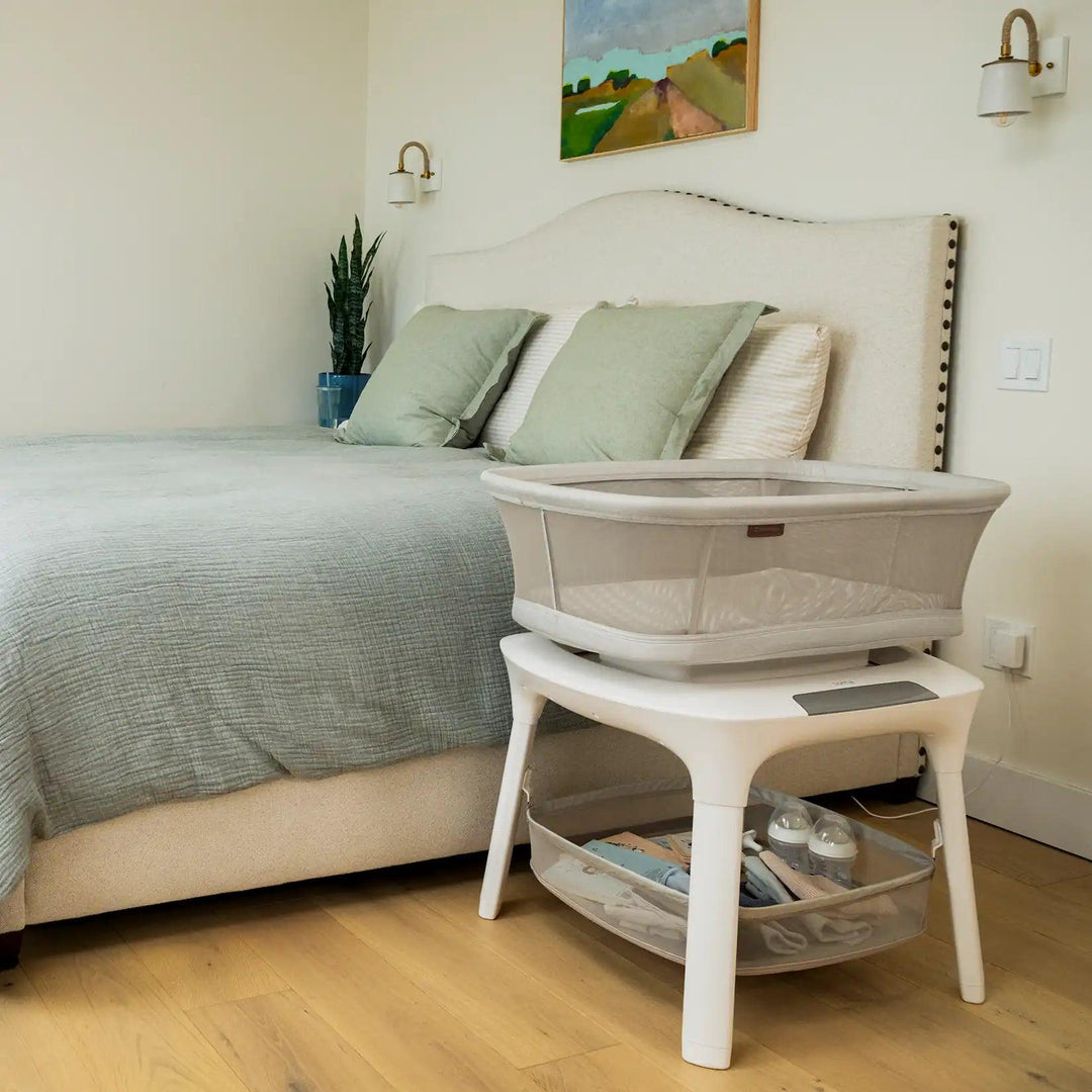bedroom with uppa baby soma smart bassinet near bed utilizing storage basket on lower frame