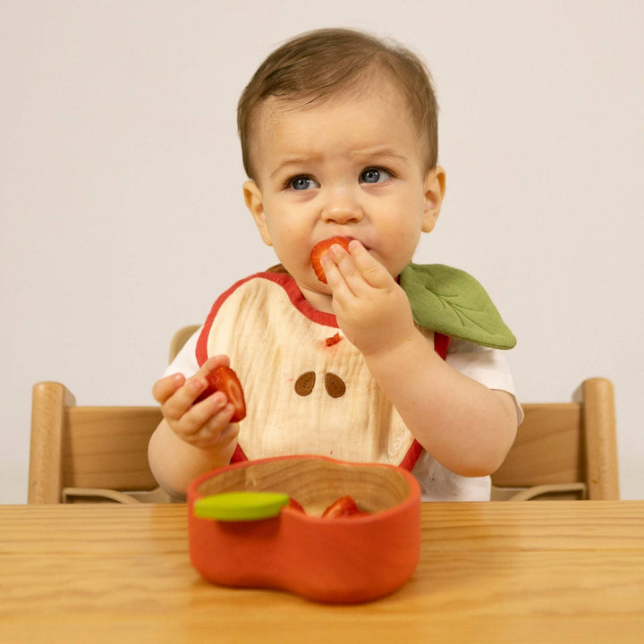 baby eating strawberry from non toxic olli and carroll wooden bowl   
