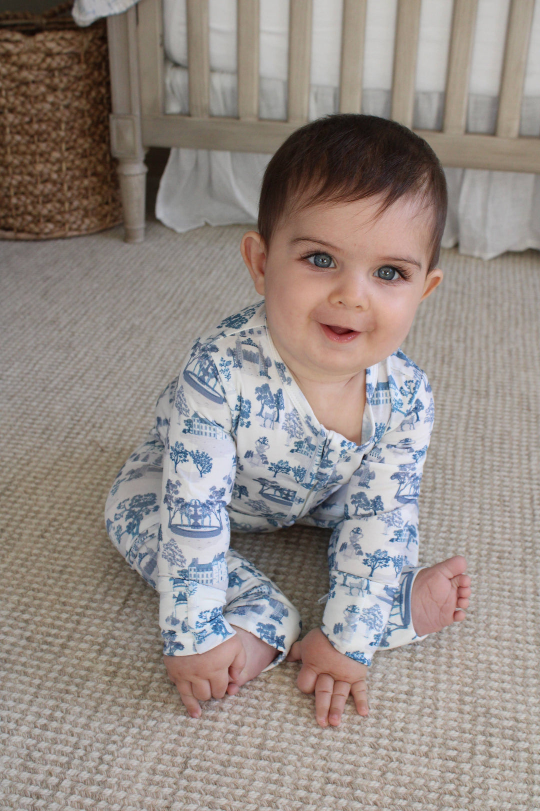 Little Threads baby footie pajama worn while crawling on a soft neutral carpet