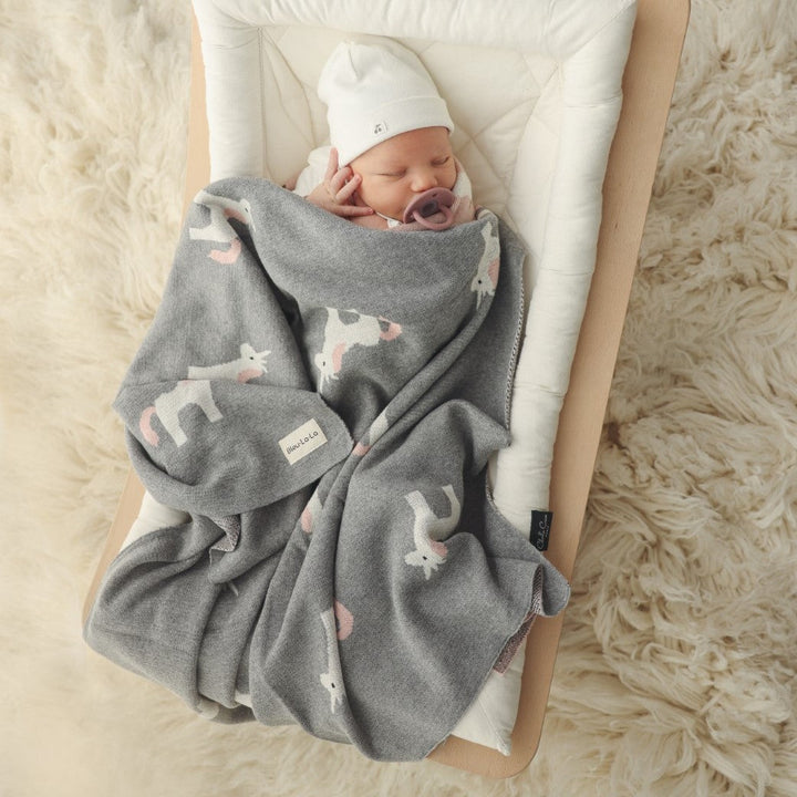Newborn baby swaddled in a Bleu La La knit unicorn blanket, lightweight breathable cotton for everyday comfort