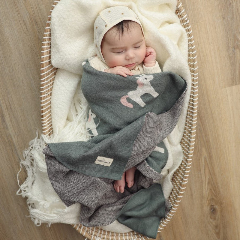 Baby wrapped snugly in a Bleu La La unicorn knit blanket, perfect for cuddles and quiet moments
