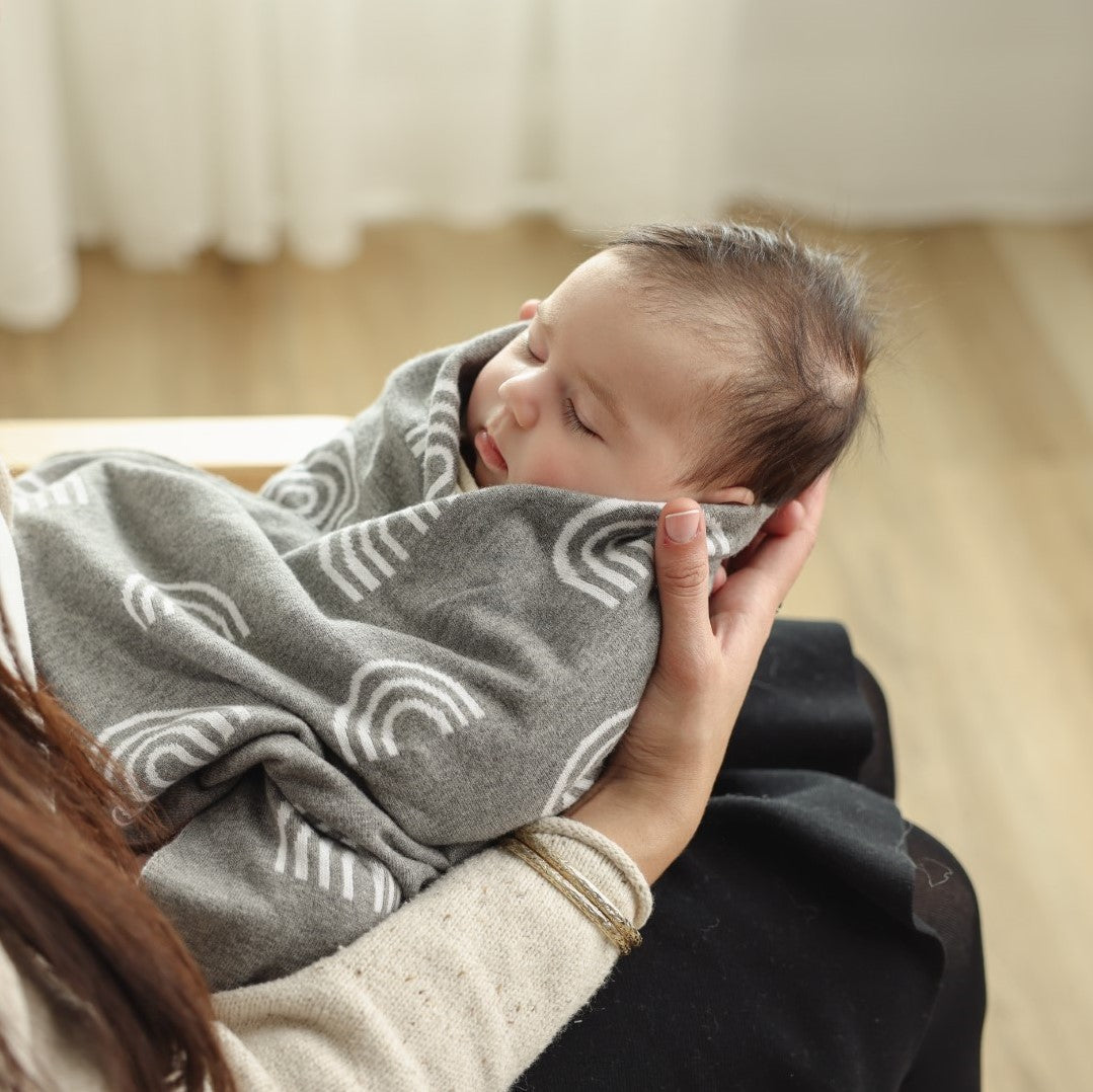 Sleeping baby wrapped in the Bleu La La Rainbow Blanket in Gray.
