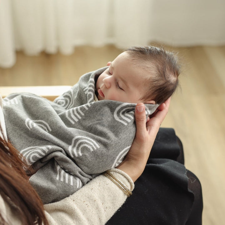 Sleeping baby wrapped in the Bleu La La Rainbow Blanket in Gray.