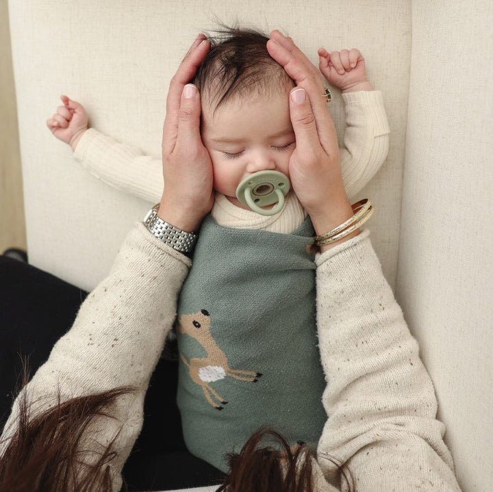 Rolled Bleu La La deer knit baby blanket showing premium cotton knit fabric and minimalist woodland style