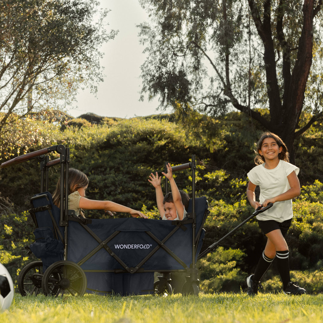 Kids stroller wagon outdoors: the Wonderfold X4R Quad Stroller Wagon Navy on all-terrain wheels