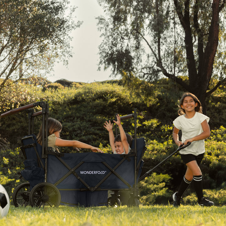Kids stroller wagon outdoors: the Wonderfold X4R Quad Stroller Wagon Navy on all-terrain wheels
