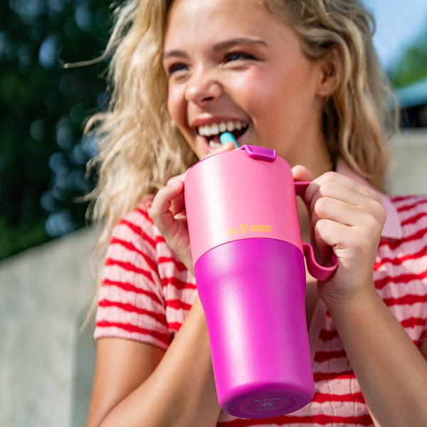 Teen smiling with Klean Kanteen 26oz Rise Tumbler in Pink Kaleidoscope, built from non toxic recycled materials for hydrating anywhere.