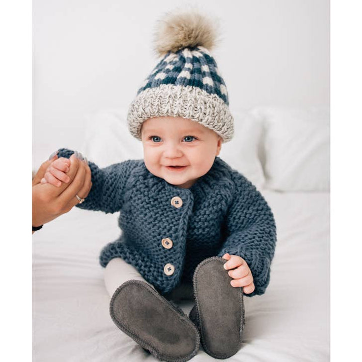 Smiling baby in Huggalugs Slate Garter Stitch sweater, gift-ready knit cardigan for toddlers