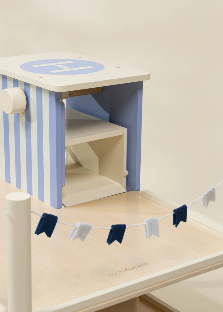 Coco Village's wooden garage playset rooftop shown with striped walls and small flags