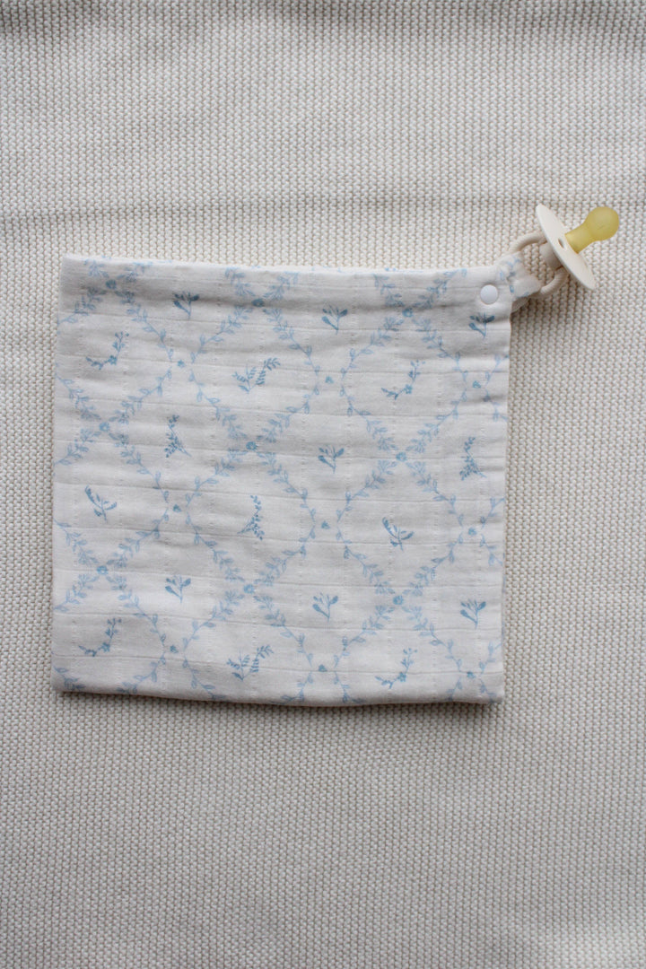 Close up of folded blue lattice lovey corner from Little Threads with clip detail