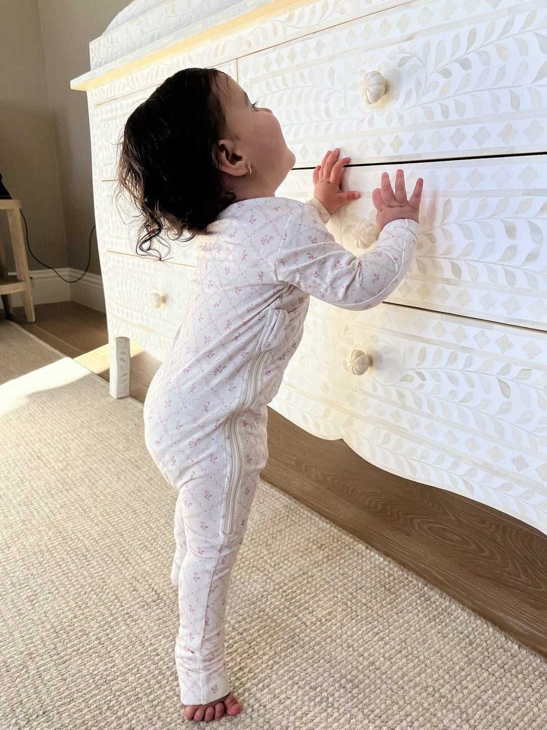 Baby standing in Little Threads mauve lattice wrap footie, soft bamboo toddler pajamas for crawling, stretching, and cozy everyday wear