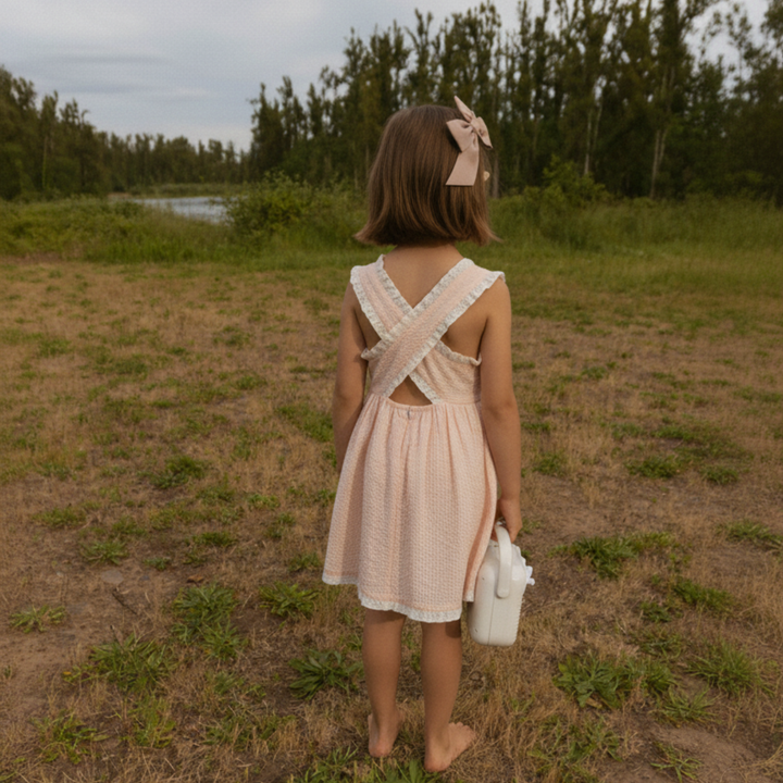 Organic blush seersucker baby dress flat lay - MakeMake Organics cross back toddler dress