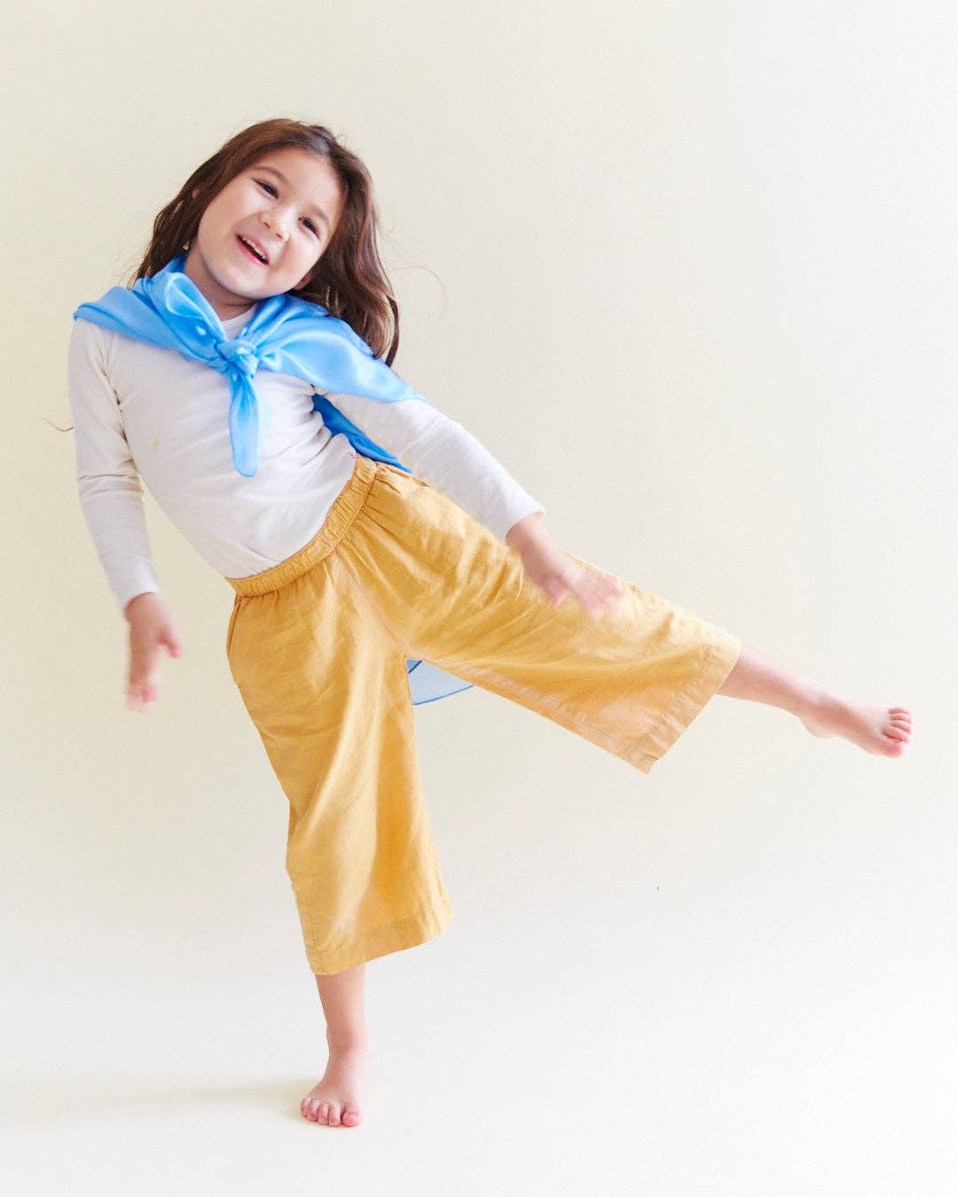 A top selling children's toy, child dancing with a blue Sarah's Silks Solid Color Playsilk