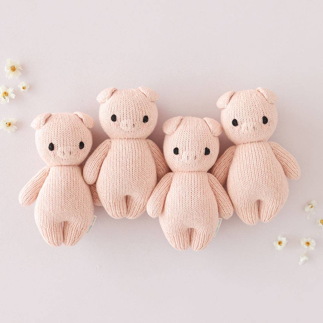 four pink baby pig stuffed animals by cuddle+kind together