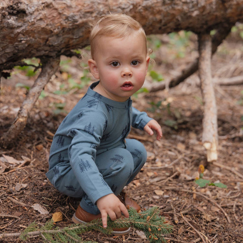 baby boy wearing dark blue city mouse romper with tree pattern in forest for baby fall outfit 