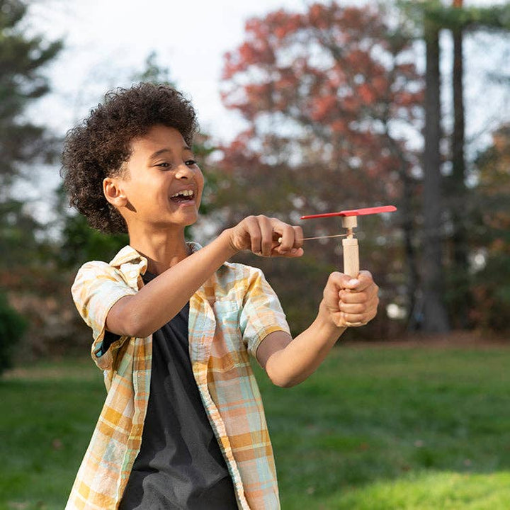Child playing with Huckleberry Pull Helicopter outdoor toy outdoors