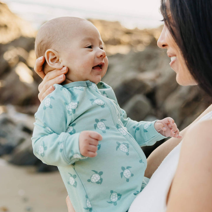 Baby being held wearing Copper Pearl Wade pajamas, soft infant sleeper for comfort and bonding moments