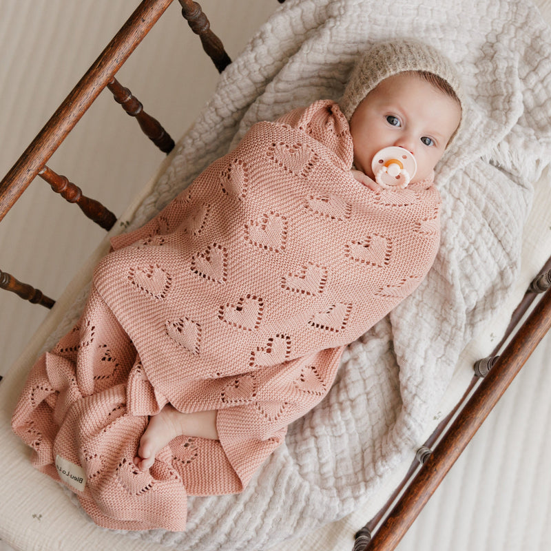 Newborn swaddled in Bleu La La 100% Cotton Luxury Knit Heart Swaddle Baby Blanket in rose pink for soft, chemical-free comfort.