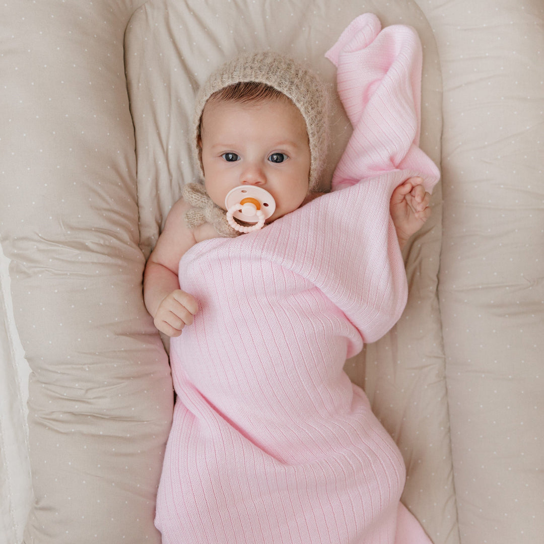 Newborn sleeping in beige Bleu La La Organic Ribbed Knit Cotton Baby Blanket, cozy ribbed organic cotton swaddle wrap