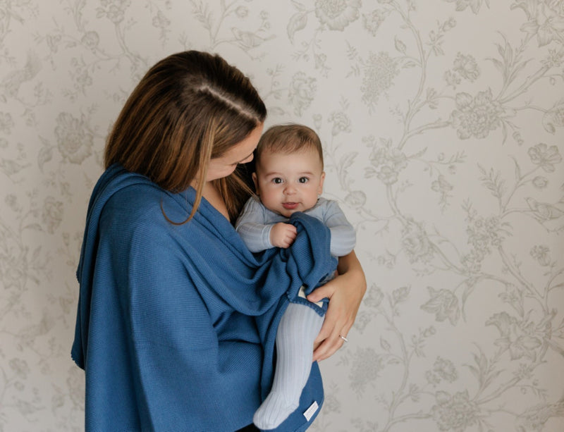 Mother holding baby wrapped in a Bleu La La organic cotton luxe baby blanket, premium knit for bonding moments