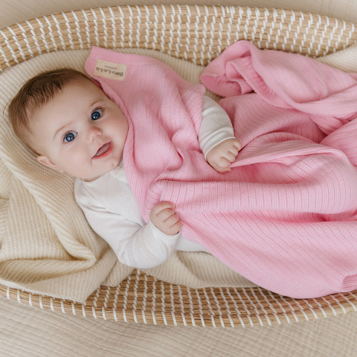 Baby wrapped in beige Bleu La La Organic Ribbed Knit Cotton Baby Blanket holding plush toy, cozy organic cotton newborn receiving blanket