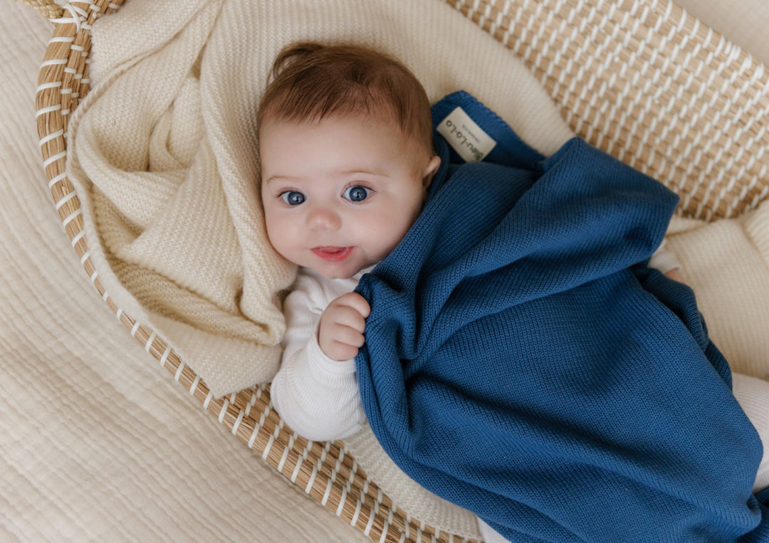 Baby swaddled in a Bleu La La organic cotton luxe blanket, breathable knit designed for gentle newborn sleep