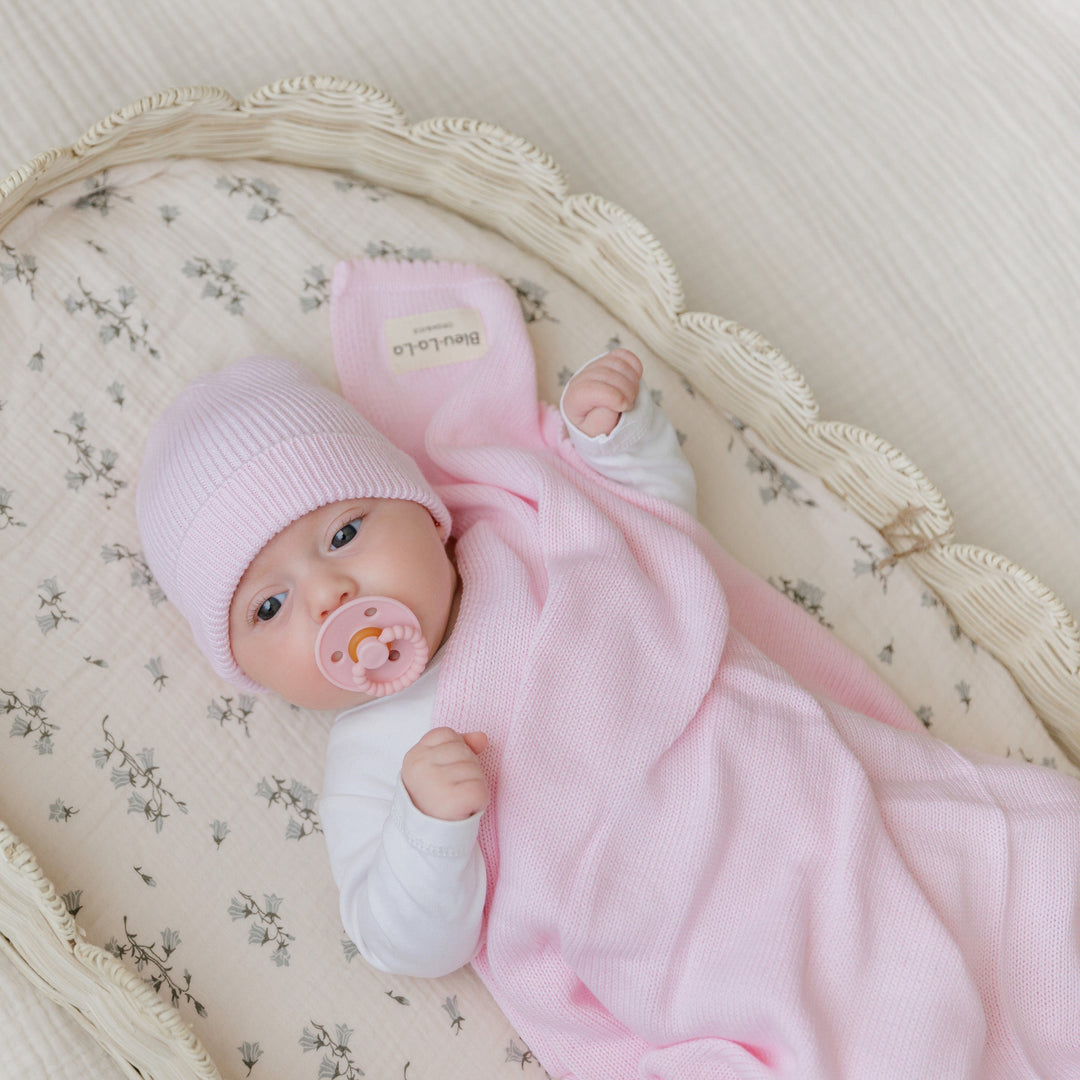 Newborn in a Bleu La La pink organic knit blanket, soft breathable cotton for naps