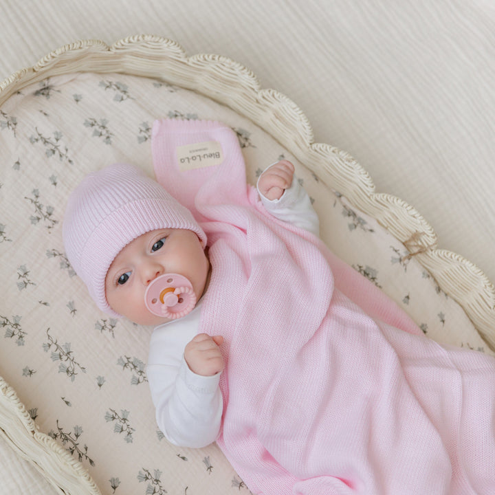 Newborn in a Bleu La La pink organic knit blanket, soft breathable cotton for naps