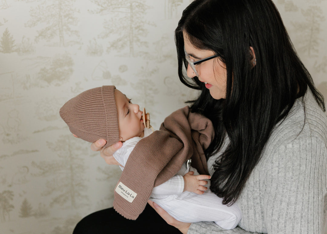 Mom holding baby in a Bleu La La brown organic knit blanket, soft organic cotton comfort