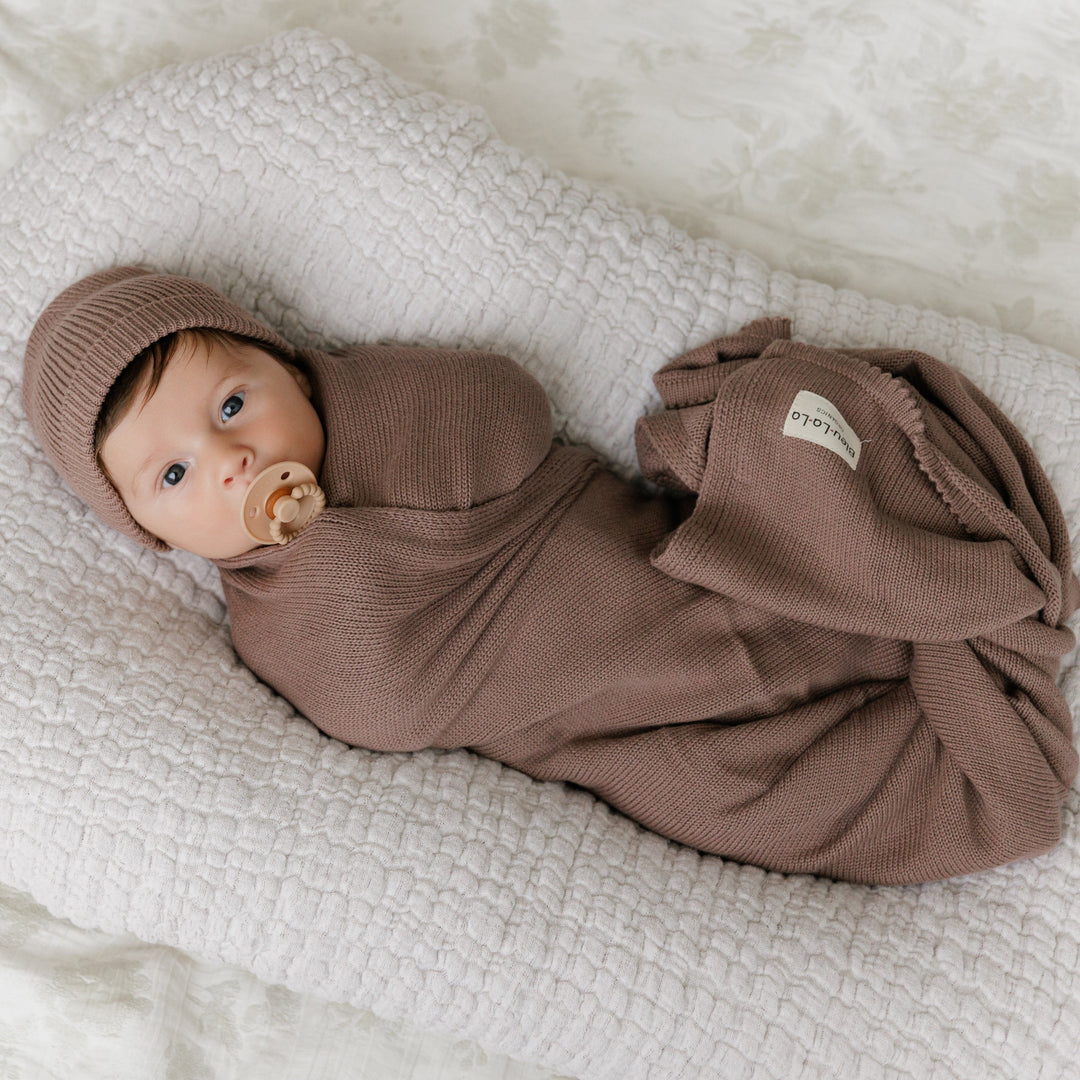 Newborn in a Bleu La La brown organic knit blanket on a textured blanket, cozy cotton feel