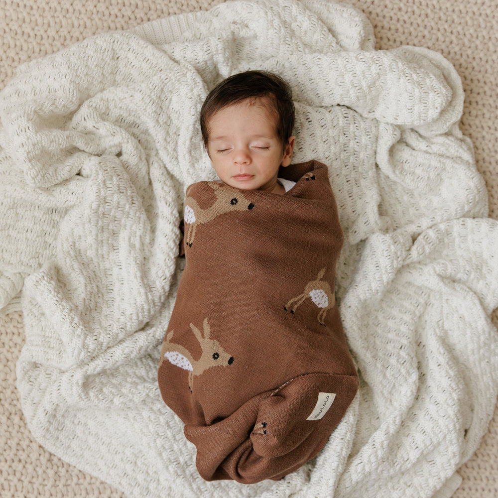 Newborn baby swaddled in a Bleu La La deer knit blanket, lightweight breathable cotton for cozy everyday comfort