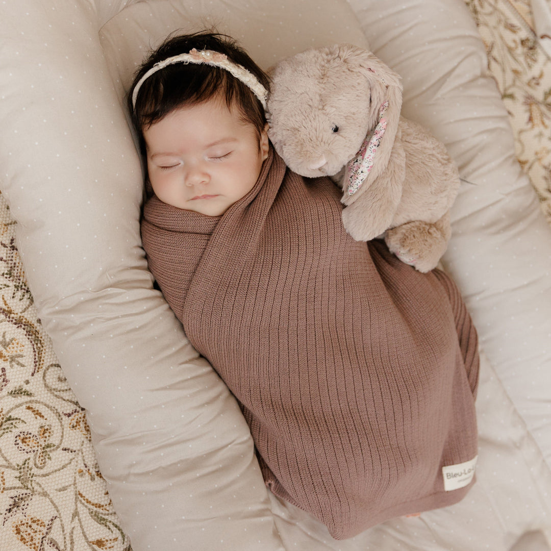Sleeping newborn wrapped in cocoa brown Bleu La La Organic Ribbed Knit Cotton Baby Blanket, warm ribbed knit swaddle blanket for infants